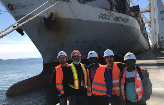 Crew on short leave standing in front of a ship