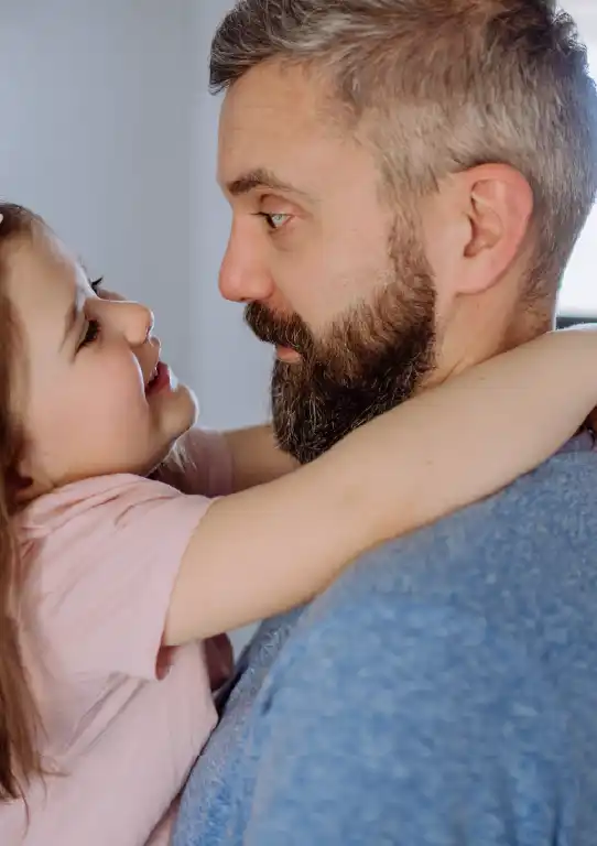 A little girl hugs her seafarer father after he gets home from a trip at sea